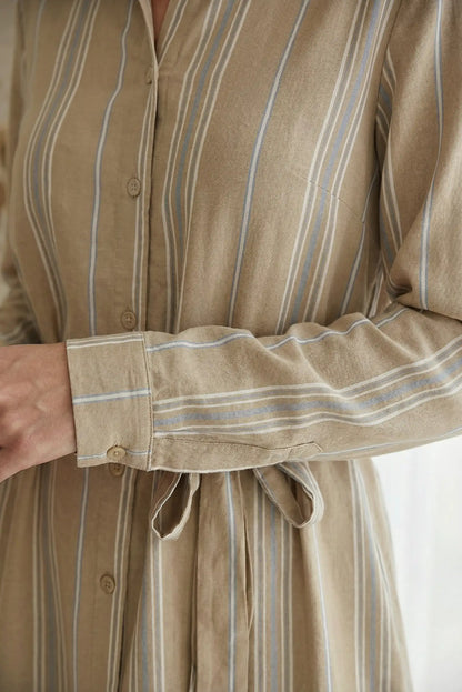 Detalle de vestido camisero de mujer, rayas camel y cinturón ajustable
