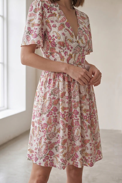 Vestido corto estampado floral con cuello en V y mangas cortas, ideal para looks casuales y estilosos.