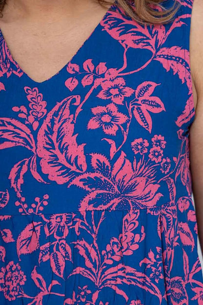 Vestido azul con estampado floral rosa, cuello en V y detalles de pliegues