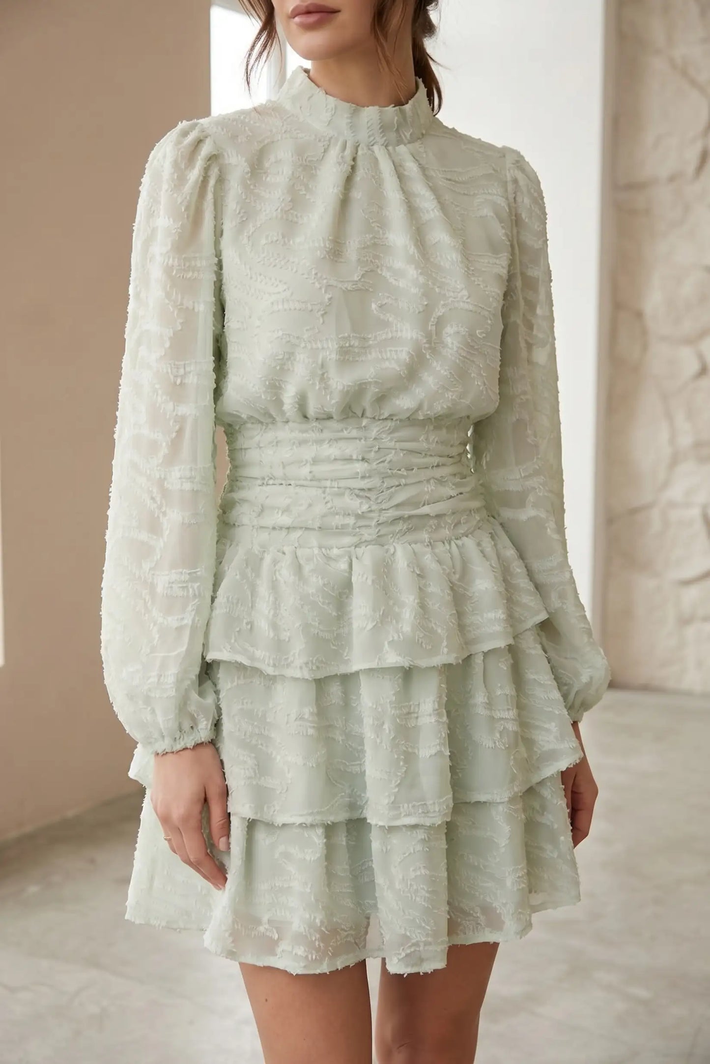 Vestido corto de mujer verde agua marina, manga larga, texturizado y con volantes.