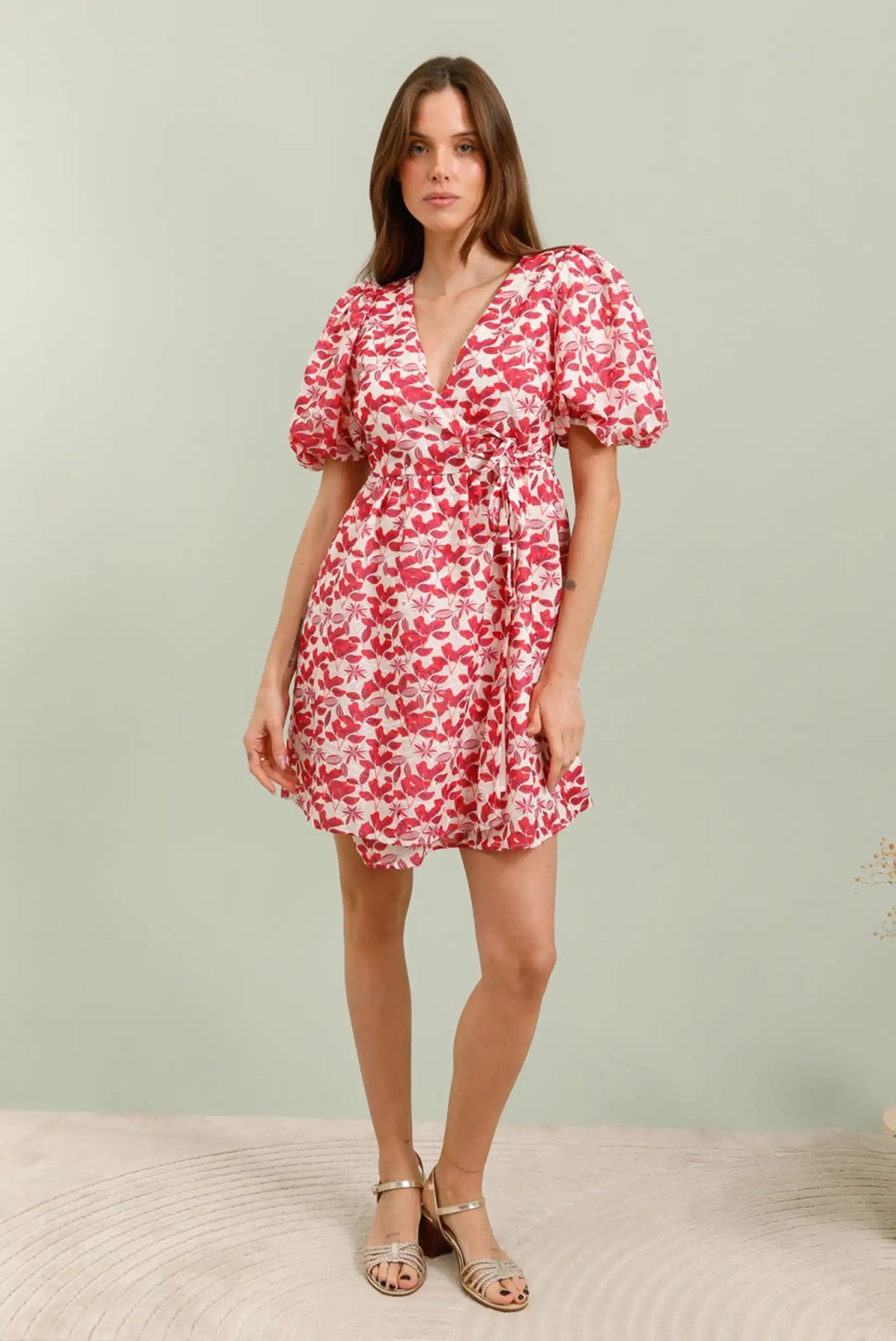 Mujer con vestido corto rojo floral de manga corta y escote en V, estilo primavera.