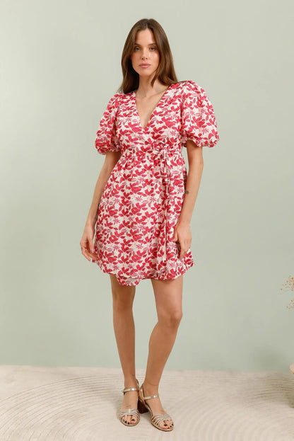 Mujer con vestido corto rojo floral de manga corta y escote en V, estilo primavera.