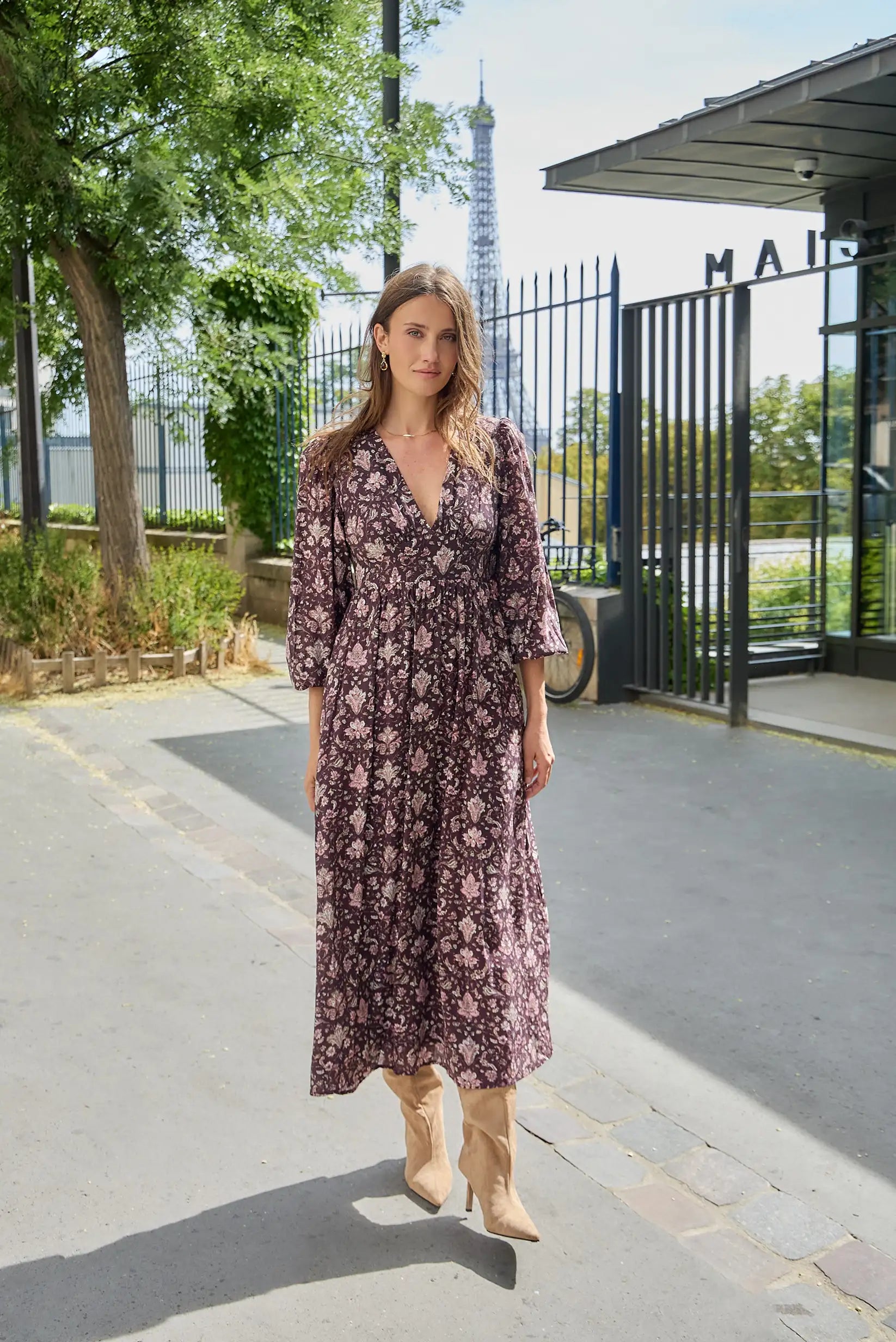 Mujer con vestido largo floral en tonos granates y botas beige en París