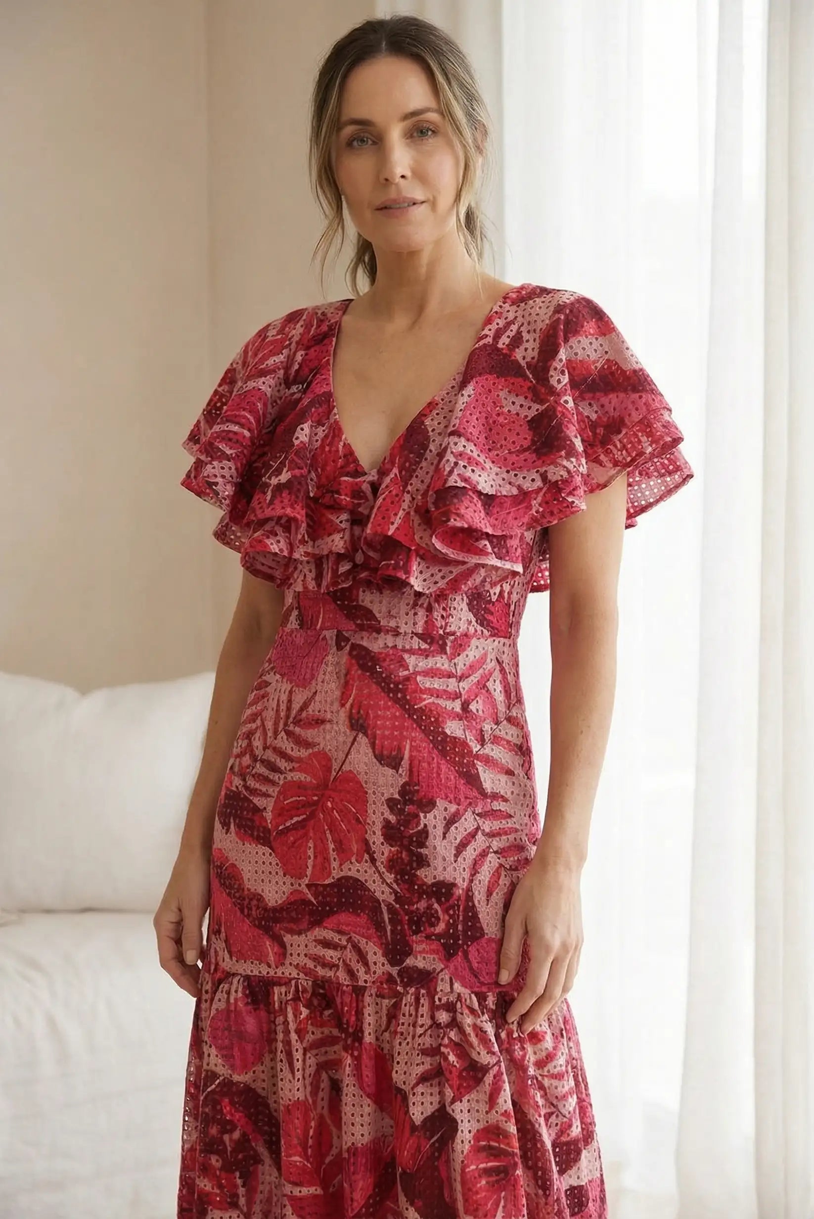 Mujer con vestido largo rojo de primavera, manga corta, estampado floral, en interior luminoso.