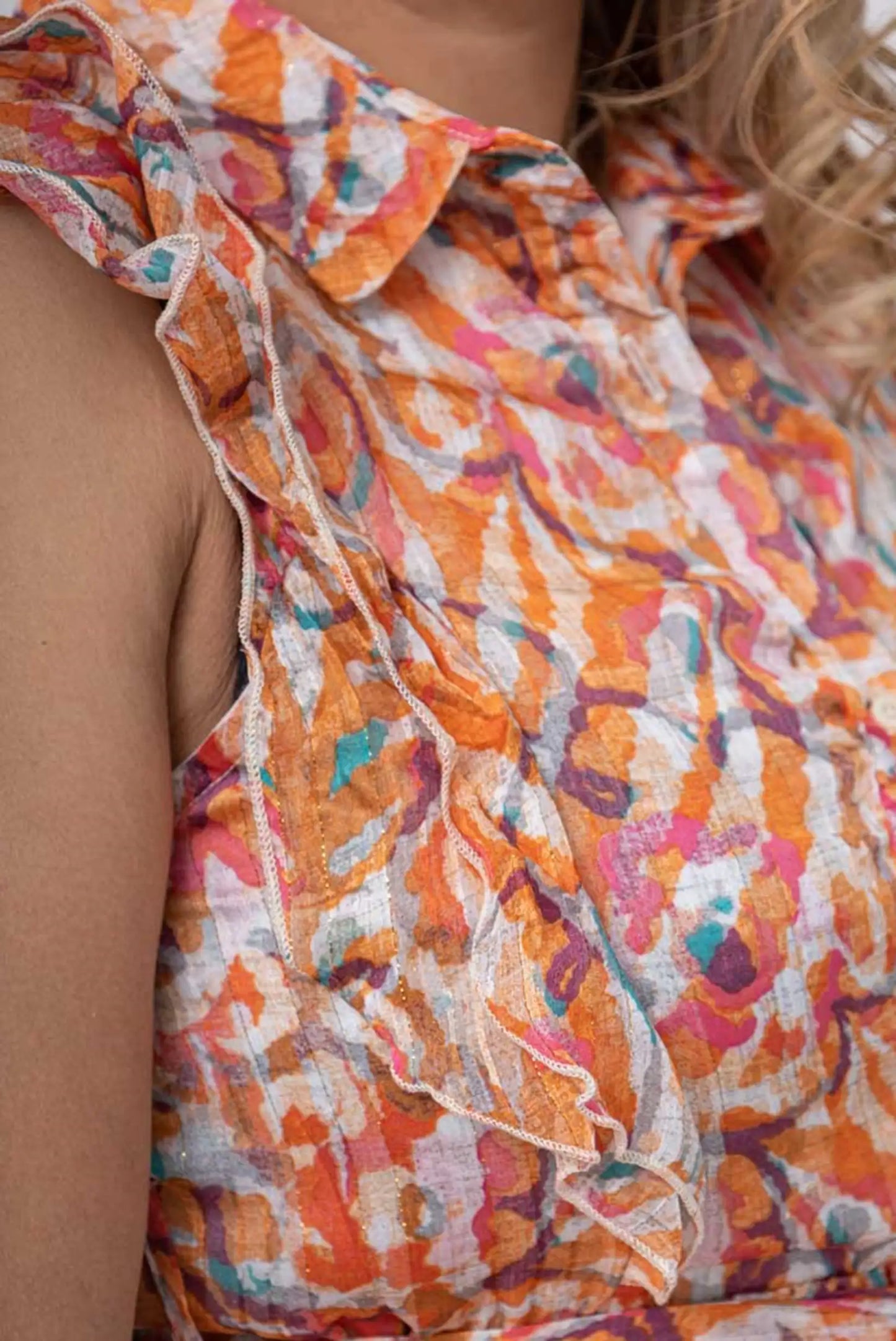 Blusa estampada con volantes en tonos naranja y rosa, ideal para moda femenina verano