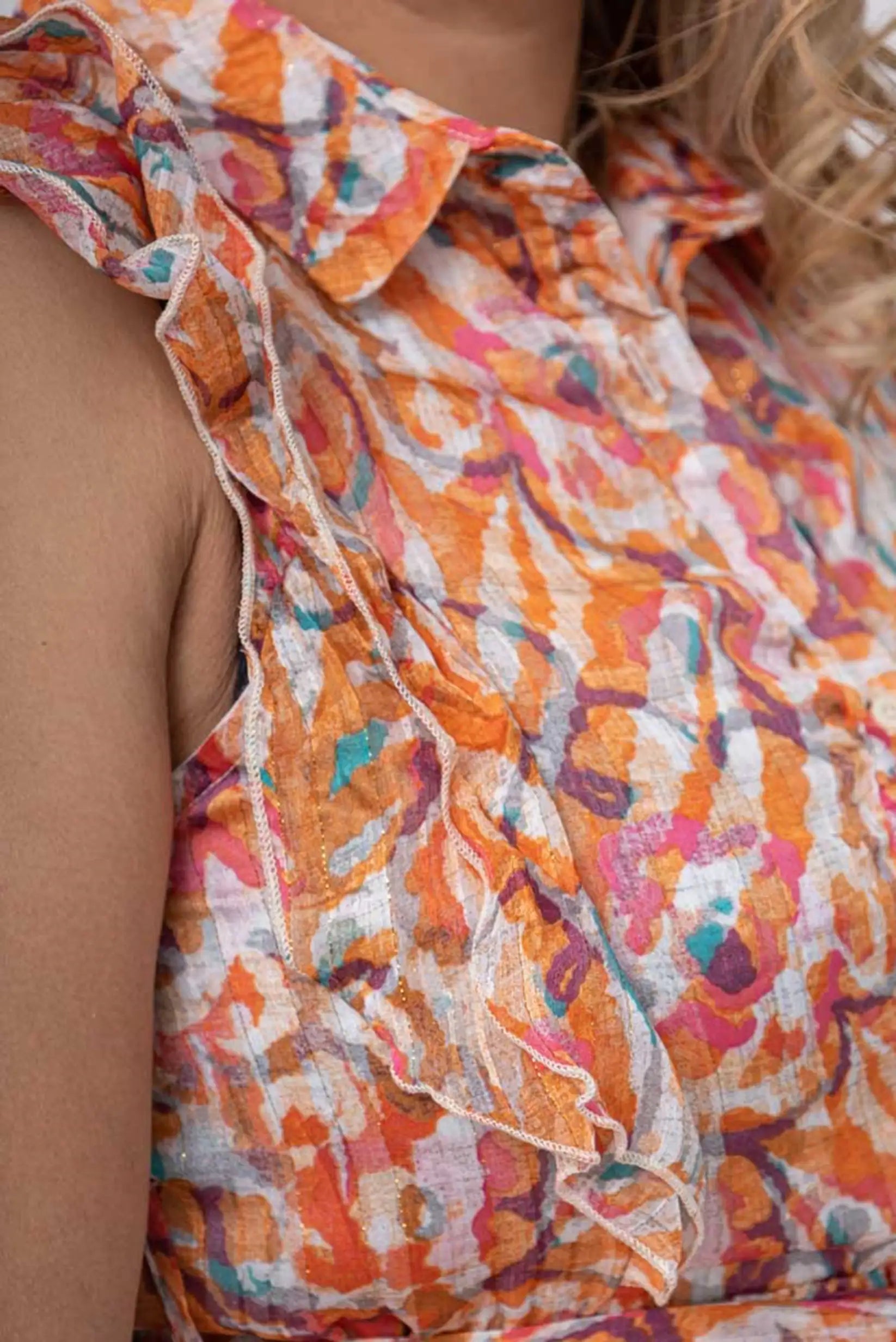 Blusa estampada con volantes en tonos naranja y rosa, ideal para moda femenina verano