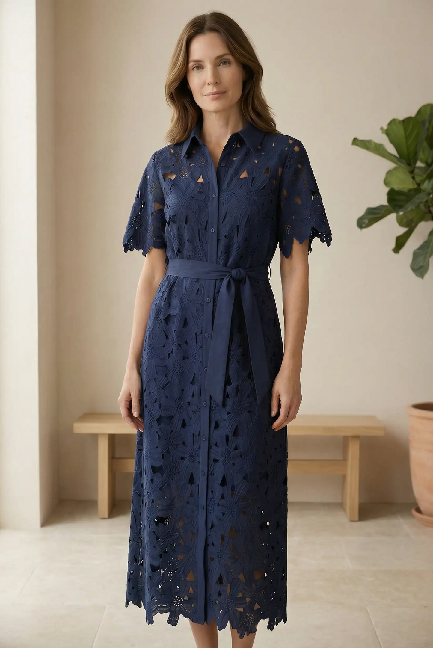 Mujer con vestido largo azul marino de encaje, manga corta, ideal para eventos elegantes.