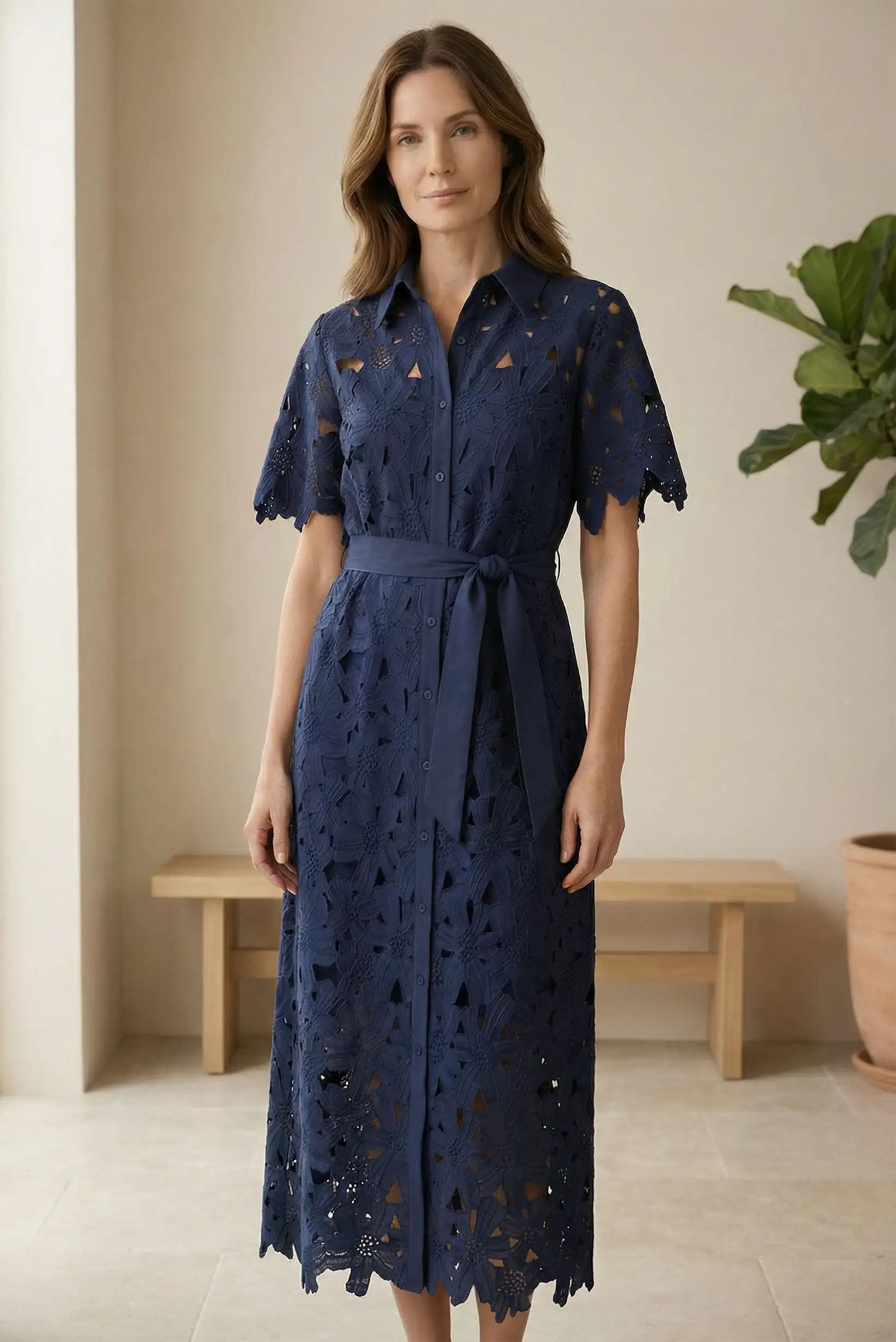 Mujer con vestido largo azul marino de encaje, manga corta, ideal para eventos elegantes.