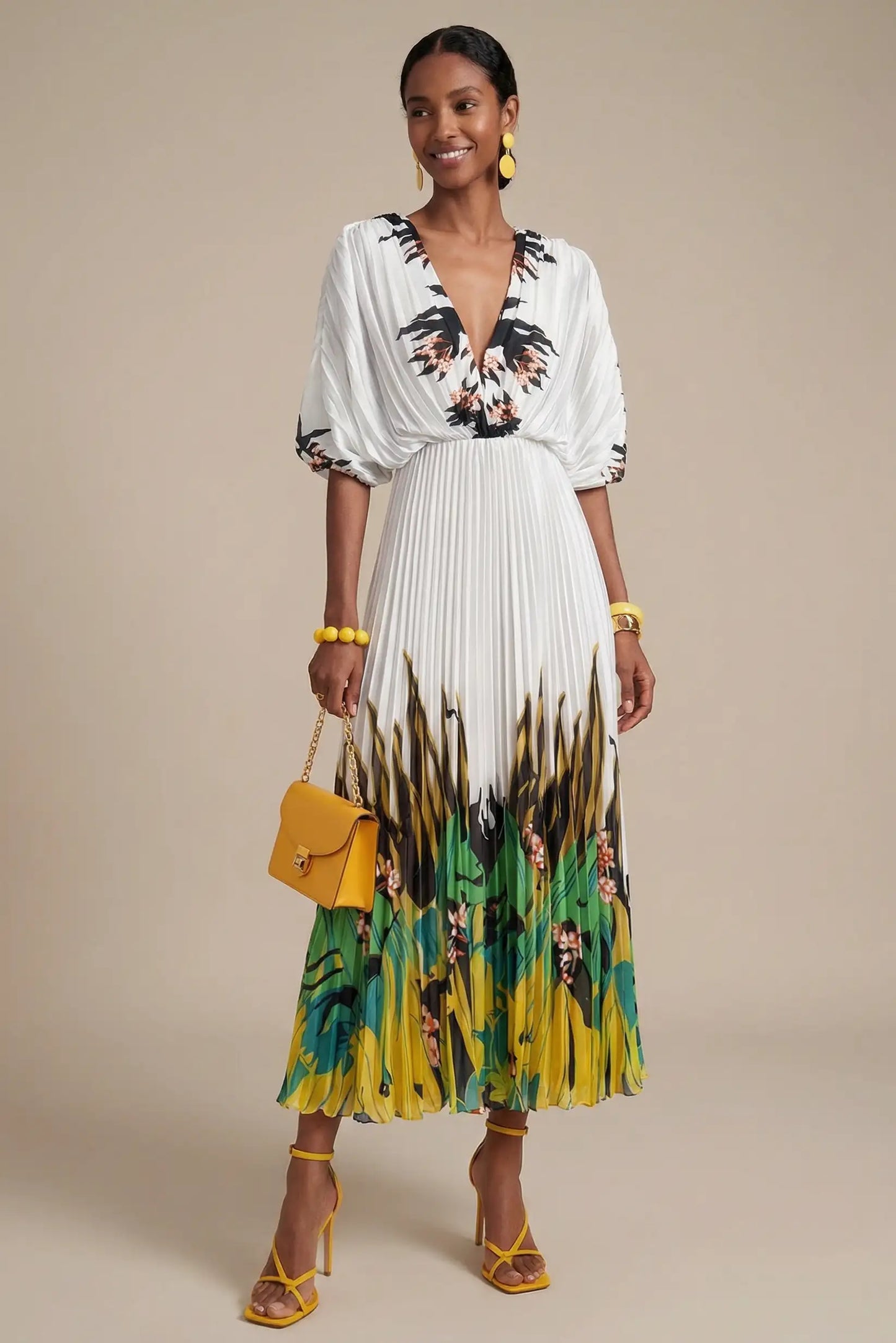 Mujer con vestido blanco plisado estampado verde tropical, bolso y sandalias amarillas.