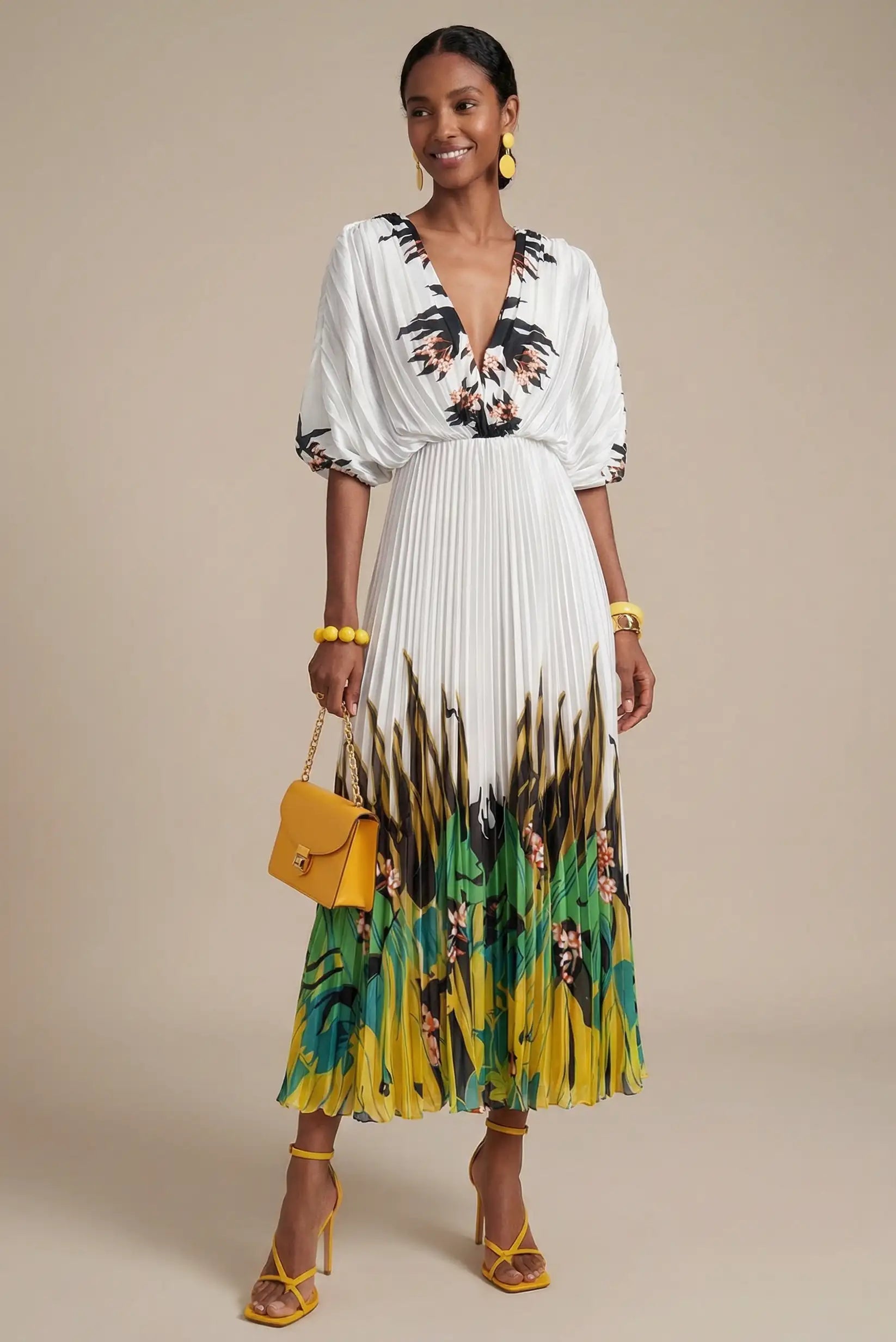 Mujer con vestido blanco plisado estampado verde tropical, bolso y sandalias amarillas.