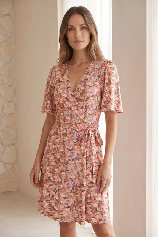 Mujer con vestido corto cruzado de flores rosas y rojas, manga corta, estilo primavera.