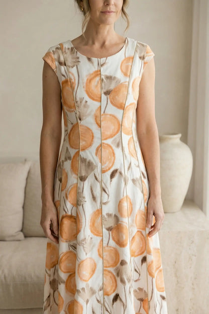 Vestido blanco de mujer con estampado floral naranja y marrón, corte midi, estilo primavera.