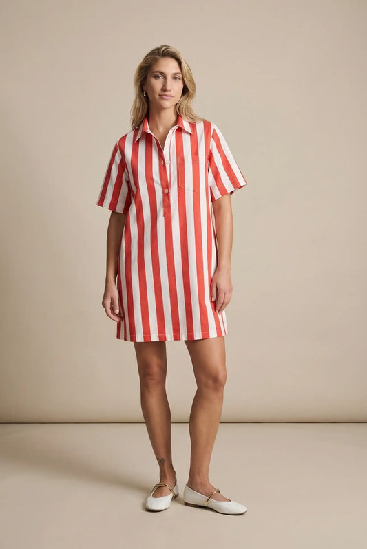 Mujer con vestido corto de primavera a rayas rojas y blancas, manga corta, fondo beige.