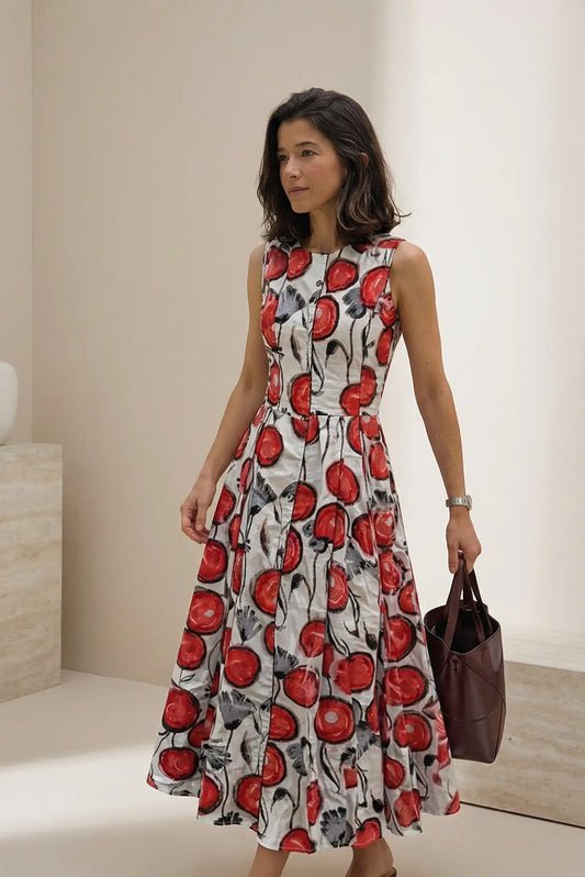 Mujer con vestido midi sin mangas estampado floral rojo y blanco, bolso marrón, estilo primavera